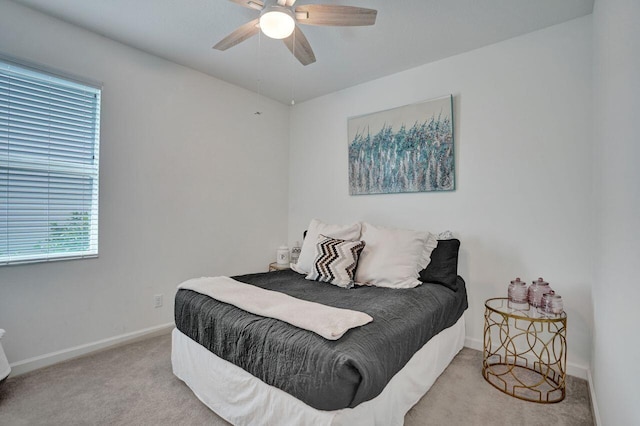 carpeted bedroom with baseboards and a ceiling fan