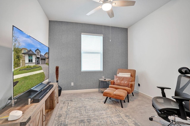 living area featuring a ceiling fan, light colored carpet, and baseboards