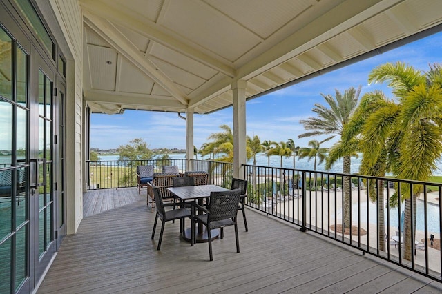 wooden deck with outdoor dining space and a water view