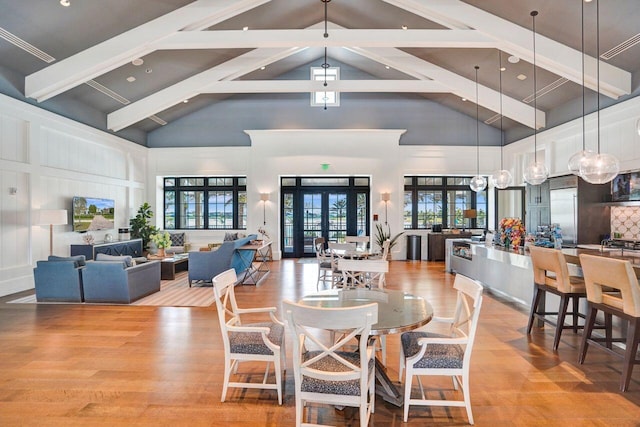 dining area featuring beamed ceiling, high vaulted ceiling, visible vents, and wood finished floors