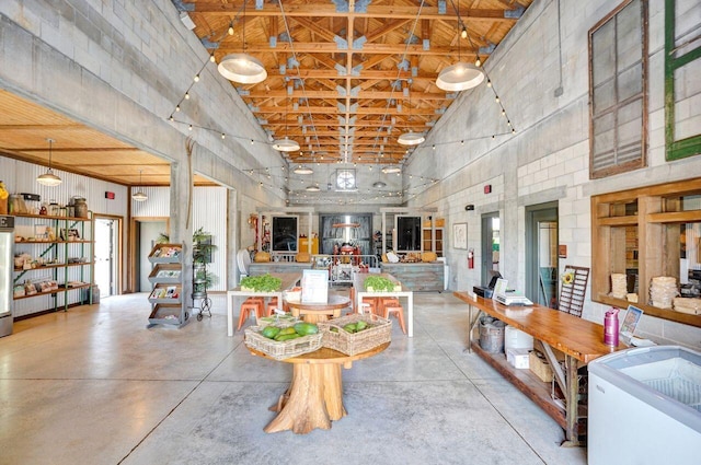 dining space with concrete flooring and a towering ceiling