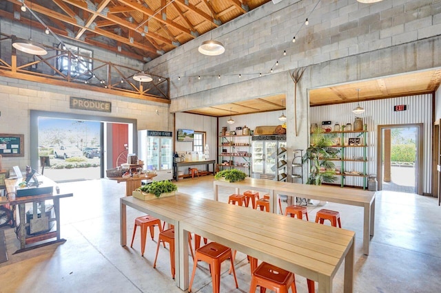 dining space with a high ceiling and concrete floors