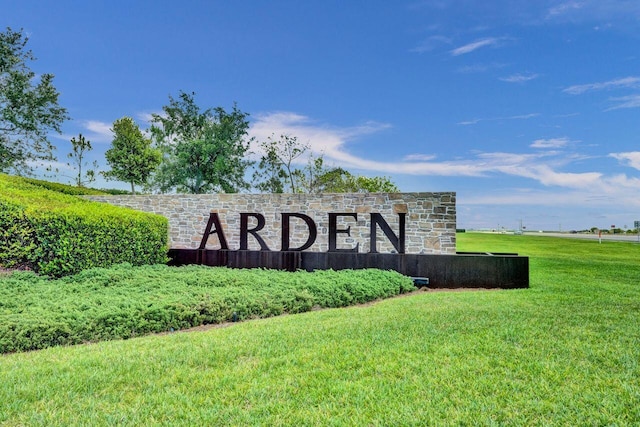 community / neighborhood sign featuring a lawn