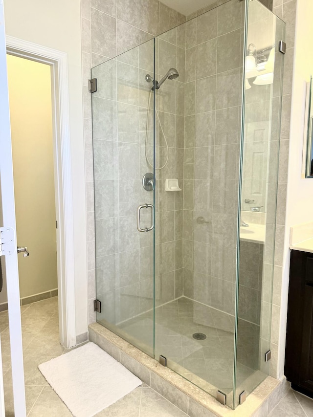 full bath with a stall shower, tile patterned flooring, and vanity