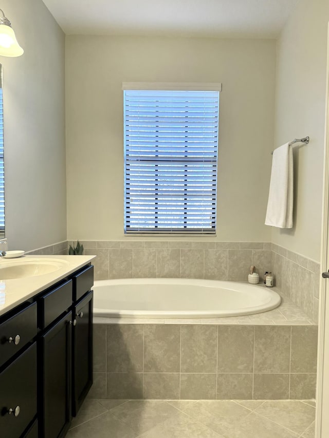 bathroom with tile patterned flooring, a garden tub, and vanity