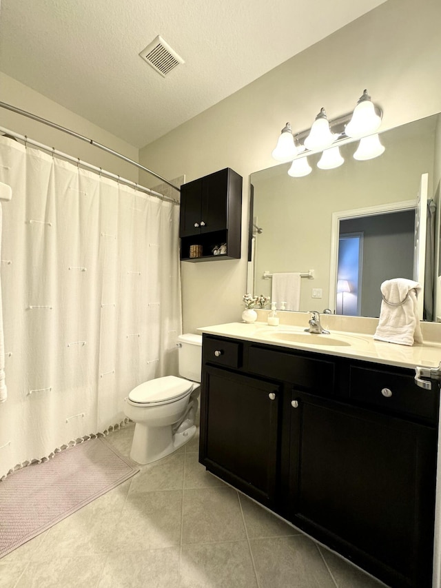 bathroom featuring visible vents, toilet, vanity, a textured ceiling, and tile patterned floors