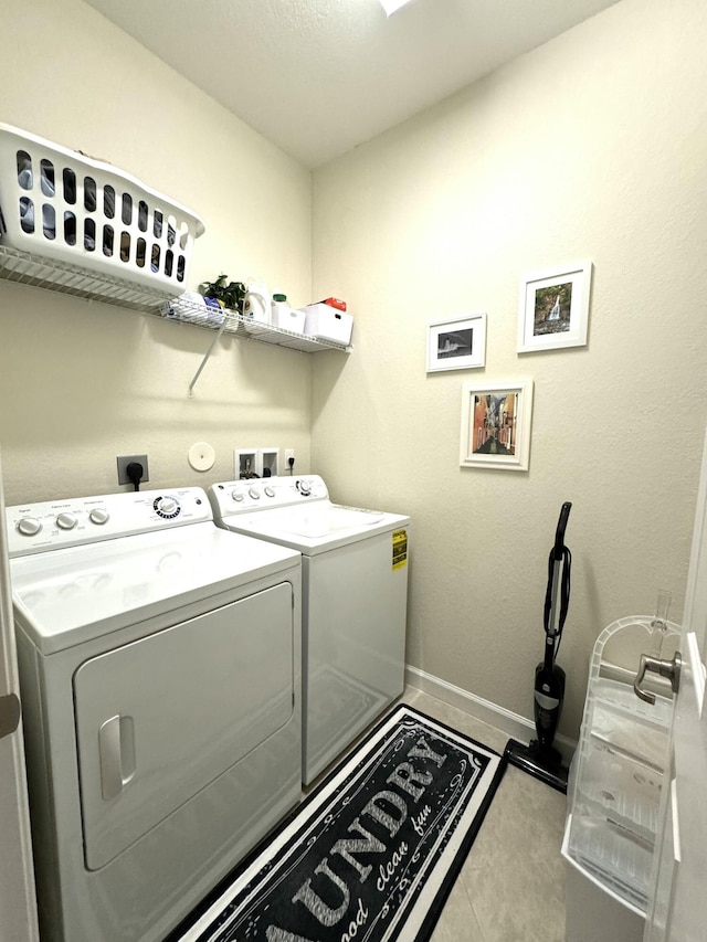 washroom featuring laundry area, tile patterned floors, baseboards, and independent washer and dryer