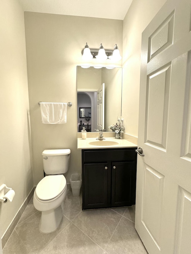 bathroom with baseboards, vanity, toilet, and tile patterned floors