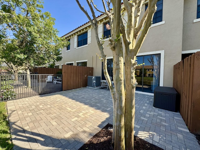 exterior space with cooling unit, fence, a tiled roof, stucco siding, and a patio area