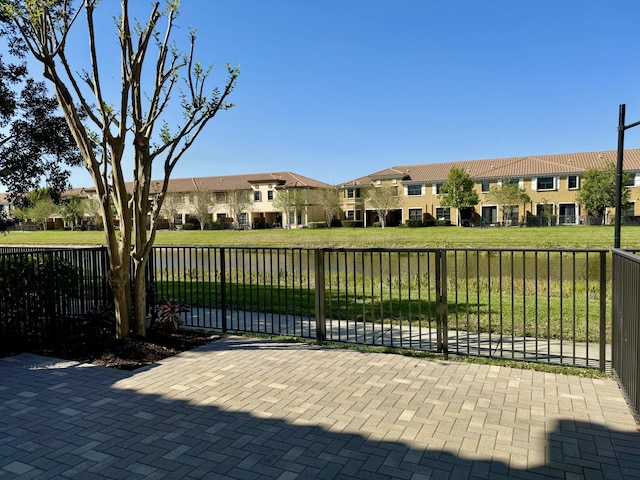 view of gate featuring a lawn, fence, and a residential view