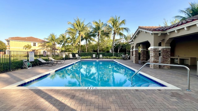 pool with a patio and fence