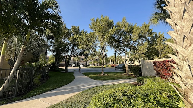 view of home's community with a yard and fence