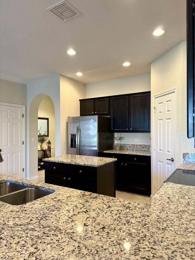 kitchen featuring stainless steel appliances, recessed lighting, a sink, light stone countertops, and a kitchen breakfast bar