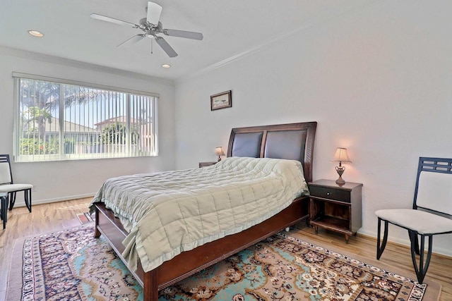 bedroom with light wood-style flooring, a ceiling fan, baseboards, and ornamental molding