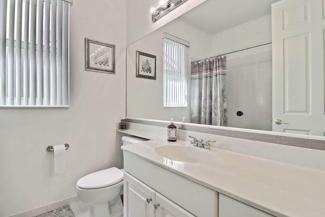 bathroom with vanity, toilet, a shower with curtain, and baseboards