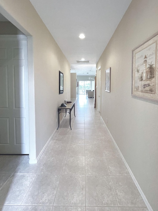 hall with light tile patterned floors and baseboards