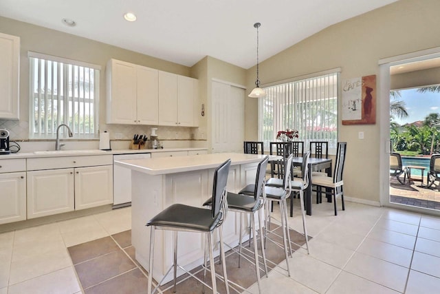 kitchen featuring light countertops, light tile patterned floors, white dishwasher, and a sink