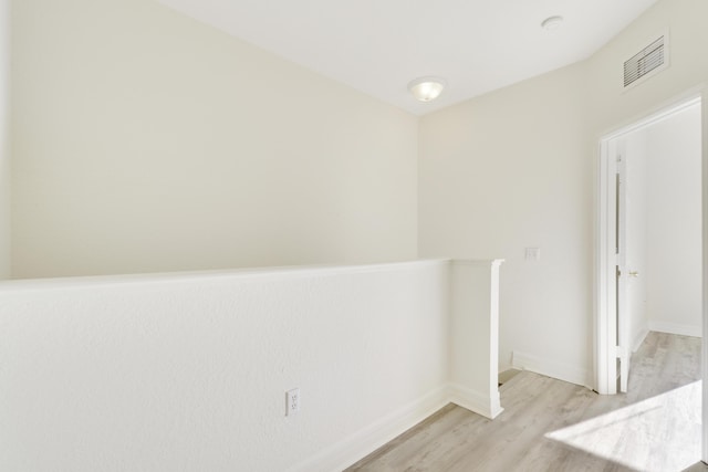 spare room with visible vents, light wood-style flooring, and baseboards