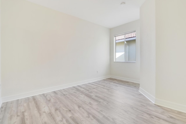 empty room featuring light wood-style floors and baseboards