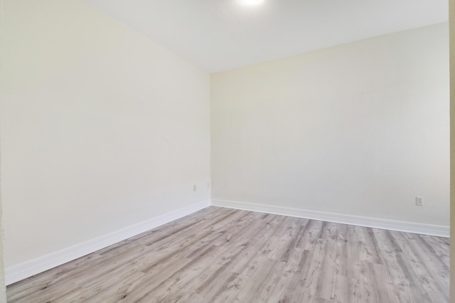 spare room featuring baseboards and light wood-style flooring