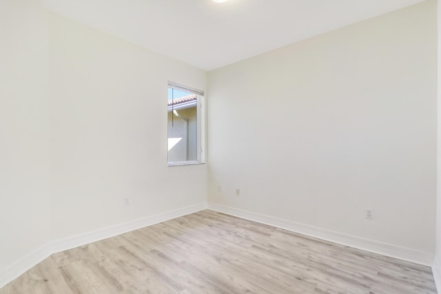 unfurnished room featuring baseboards and light wood-style flooring