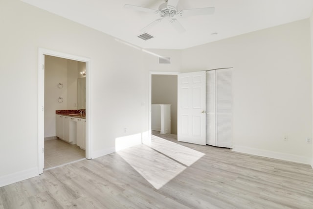 interior space featuring a ceiling fan, baseboards, visible vents, light wood-style flooring, and a sink