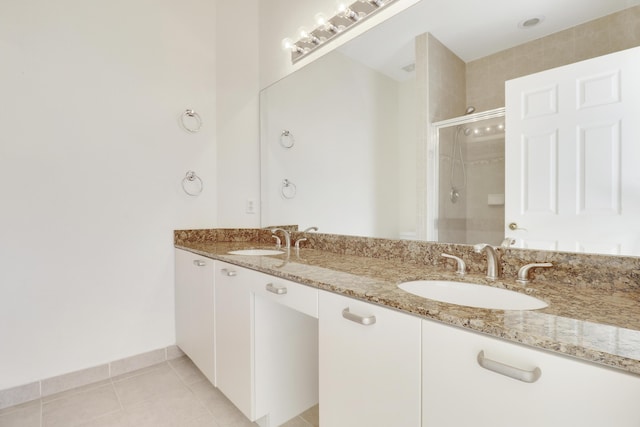 bathroom with a sink, double vanity, a shower stall, and tile patterned flooring