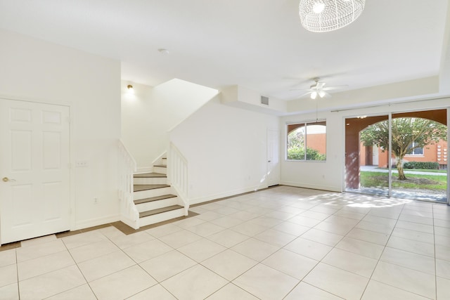 interior space with light tile patterned floors, visible vents, stairs, and a ceiling fan