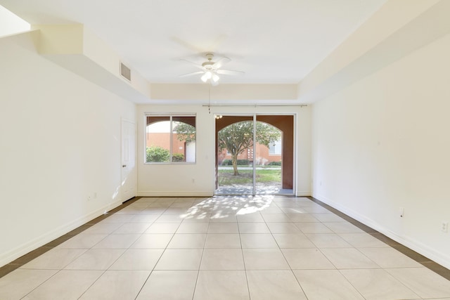 empty room with light tile patterned floors, visible vents, baseboards, and ceiling fan