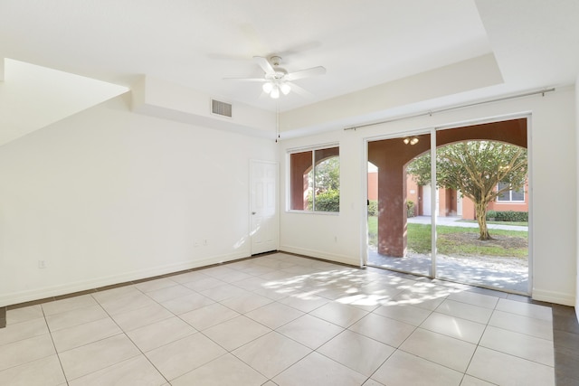 unfurnished room featuring light tile patterned floors, a ceiling fan, visible vents, and baseboards