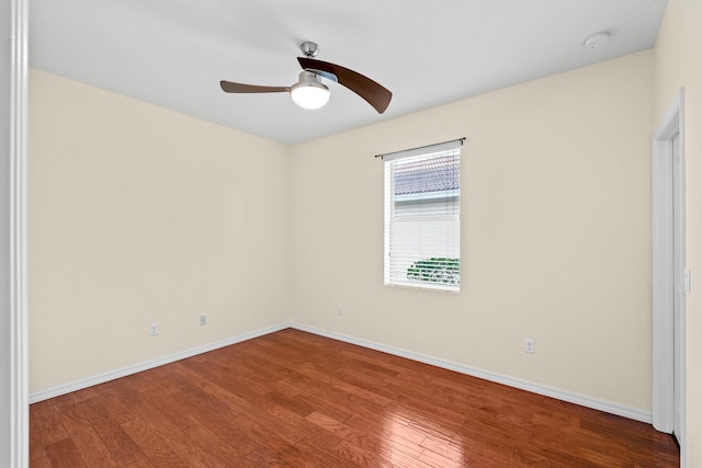 spare room featuring a ceiling fan, wood finished floors, and baseboards