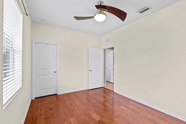 unfurnished bedroom featuring visible vents, baseboards, and wood finished floors