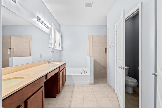 bathroom featuring tile patterned floors, a garden tub, visible vents, and a sink