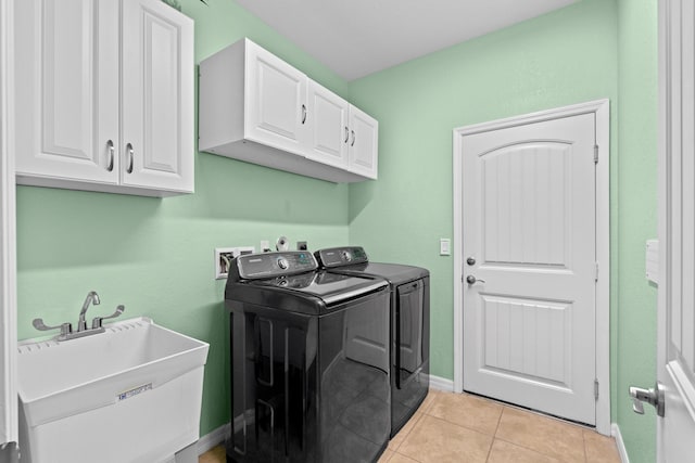 laundry area with light tile patterned floors, baseboards, cabinet space, a sink, and washer and clothes dryer