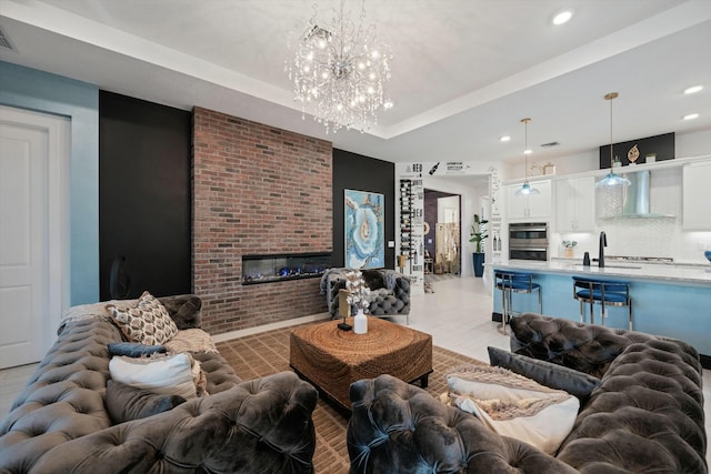 living area featuring a tray ceiling, a brick fireplace, visible vents, and recessed lighting