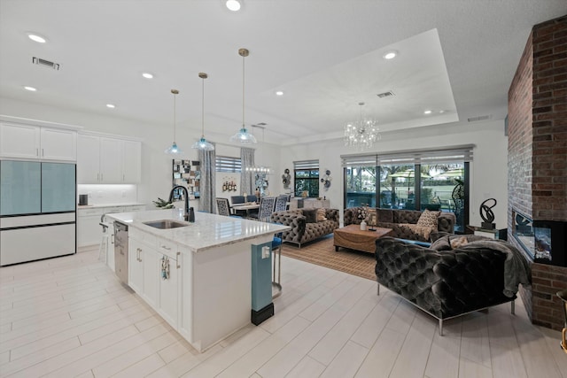 kitchen with open floor plan, built in refrigerator, a sink, and a wealth of natural light