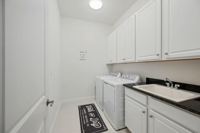 laundry room with light tile patterned floors, cabinet space, washing machine and dryer, a sink, and baseboards