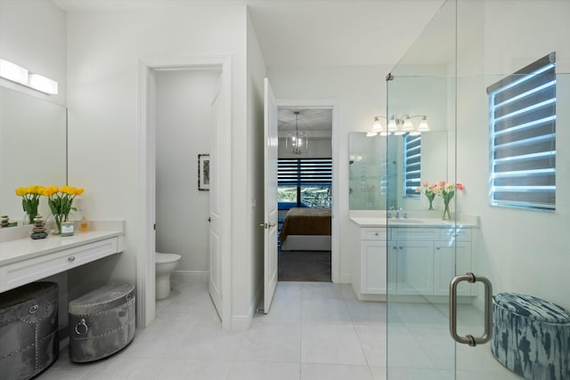 bathroom with toilet, tile patterned floors, vanity, and ensuite bathroom