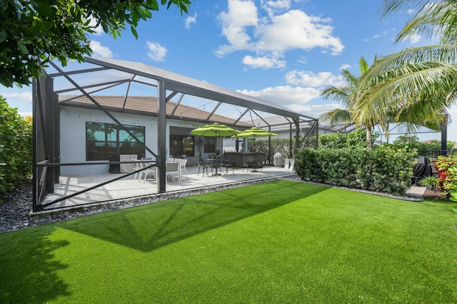 exterior space with a patio, a yard, and glass enclosure