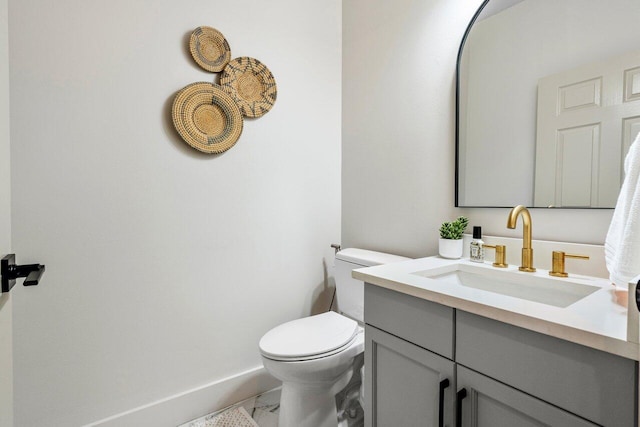 bathroom featuring vanity, toilet, and baseboards