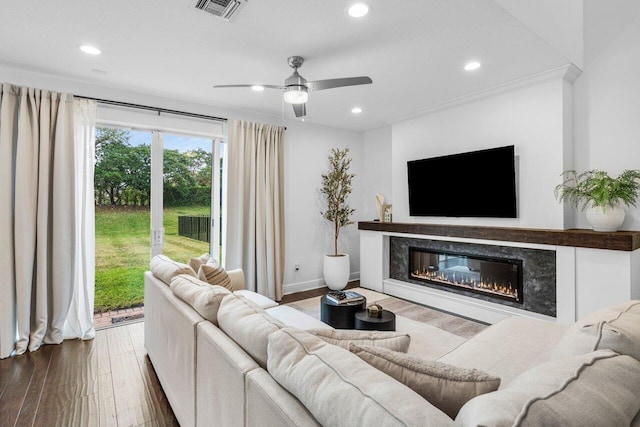 living area with visible vents, ceiling fan, a premium fireplace, recessed lighting, and wood-type flooring