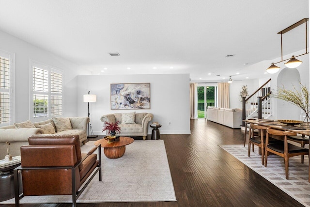 living area featuring dark wood finished floors, stairs, recessed lighting, and a wealth of natural light