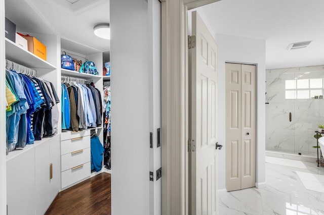 walk in closet with visible vents and marble finish floor