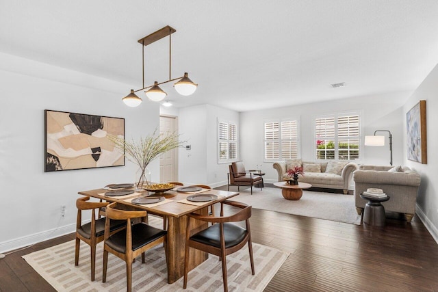 dining space featuring visible vents, baseboards, stairway, arched walkways, and wood-type flooring