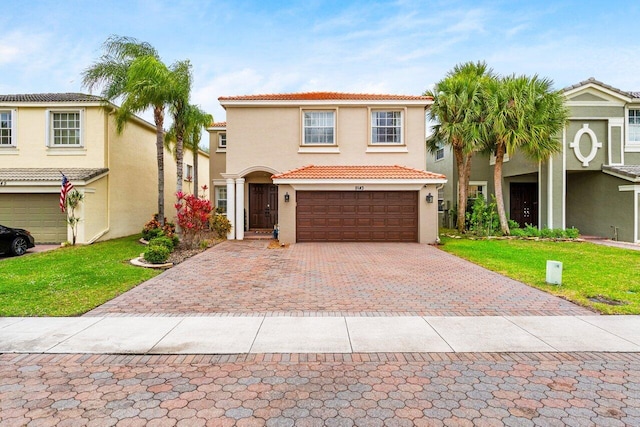 mediterranean / spanish-style house featuring stucco siding, a front lawn, a tile roof, decorative driveway, and a garage