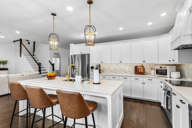 kitchen with dark wood-style floors, white cabinets, appliances with stainless steel finishes, and light countertops