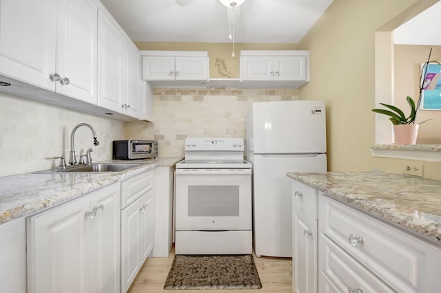 kitchen with white appliances, a sink, white cabinetry, and tasteful backsplash