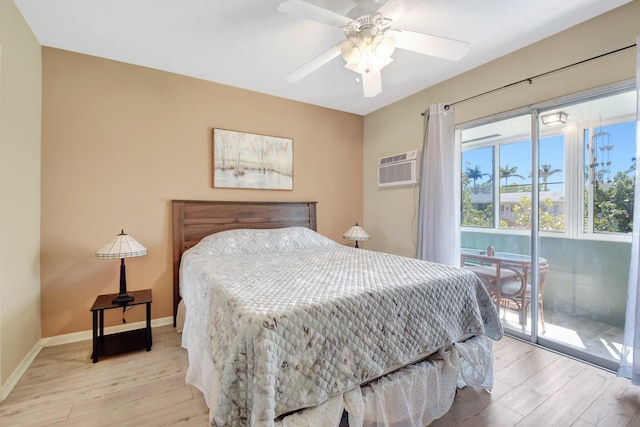 bedroom featuring baseboards, light wood-style floors, a wall mounted air conditioner, and access to exterior