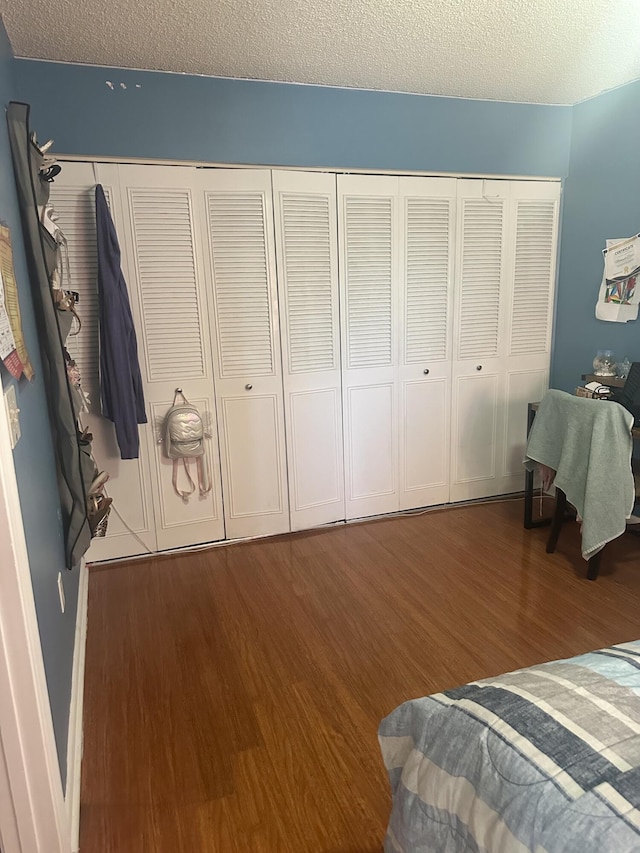 bedroom with wood finished floors, a closet, and a textured ceiling