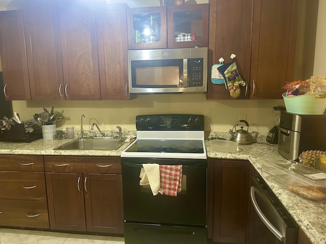 kitchen with a sink, stainless steel appliances, dark brown cabinets, and light countertops